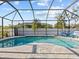 Screened-in pool area with dolphin art on concrete, lounge chairs, and lush landscaping for privacy at 821 Greenview Dr, Apollo Beach, FL 33572