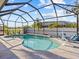 Beautiful screened-in pool with blue water, a white fence, lounge chairs, and sunny skies at 821 Greenview Dr, Apollo Beach, FL 33572
