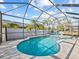 Beautiful screened-in pool with blue water, a white fence, lounge chairs, and sunny skies at 821 Greenview Dr, Apollo Beach, FL 33572