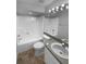 Bright bathroom featuring a tub-shower combo, white toilet, and a gray vanity with a white sink at 8103 Rhanbuoy Rd, Spring Hill, FL 34606