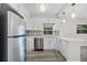 Well-lit kitchen featuring stainless steel appliances, white cabinetry, and a decorative backsplash at 1906 E Ida St, Tampa, FL 33610