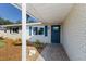 Charming front porch with brick accents, a blue door, and a well landscaped yard at 3207 33Rd Street W Ct, Bradenton, FL 34205