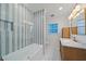 Modern bathroom with a blue-and-white-striped tub/shower, tiled floors, and wooden vanity at 7746 Westmoreland Dr, Sarasota, FL 34243