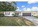 Charming single-story home with a well-manicured lawn, stone walkway, and a two-car garage at 7746 Westmoreland Dr, Sarasota, FL 34243
