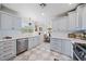 Well-lit kitchen with stainless steel appliances, white countertops, and blue cabinetry at 7746 Westmoreland Dr, Sarasota, FL 34243