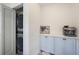 Convenient laundry area features a stackable washer/dryer and blue storage cabinets with countertop at 7746 Westmoreland Dr, Sarasota, FL 34243