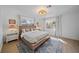 Bright main bedroom featuring a bed between two windows, hardwood floors and a cozy rug at 7746 Westmoreland Dr, Sarasota, FL 34243