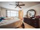 Bright bedroom with a ceiling fan, natural lighting, and dresser with mirror at 8700 Powderhorn Row, Hudson, FL 34667