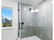 Walk-in shower with light grey vertical tiling, and a bright window with a view at 1903 Gulfview Dr, Holiday, FL 34691
