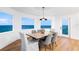 Dining room with ocean views, wood floors, modern chandelier, and seating for six at 1903 Gulfview Dr, Holiday, FL 34691
