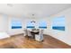 Dining room with ocean views, wood floors, modern chandelier, and seating for six at 1903 Gulfview Dr, Holiday, FL 34691