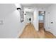 Bright hallway featuring wood floors, modern lighting, and decorative art at 1903 Gulfview Dr, Holiday, FL 34691