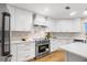 Bright kitchen with stainless steel appliances, white cabinets, quartz countertops, and modern hardware at 1903 Gulfview Dr, Holiday, FL 34691