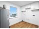 Bright laundry room with white cabinets, vinyl flooring, and a window with a view at 1903 Gulfview Dr, Holiday, FL 34691
