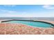 An inviting pool area overlooks the ocean with brick pavers at 1903 Gulfview Dr, Holiday, FL 34691