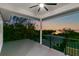 Spacious covered balcony with sunset view, iron railing, and ceiling fan at 606 Indiana Ave, Crystal Beach, FL 34681