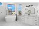 Modern bathroom with soaking tub, double vanity, and lots of natural light at 606 Indiana Ave, Crystal Beach, FL 34681