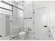 Modern bathroom showcasing a glass-enclosed shower, toilet, and stylish tile flooring at 606 Indiana Ave, Crystal Beach, FL 34681