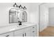 Bright bathroom featuring a modern vanity with quartz countertop and decorative mirror at 606 Indiana Ave, Crystal Beach, FL 34681