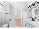 Bright bathroom with a sleek vanity, tiled floors, and an open doorway to a bedroom at 606 Indiana Ave, Crystal Beach, FL 34681