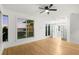 Bright bedroom featuring hardwood floors, ceiling fan, and large windows with water views at 606 Indiana Ave, Crystal Beach, FL 34681