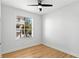 Bedroom with hardwood floors, ceiling fan, and window overlooking a neighborhood at 606 Indiana Ave, Crystal Beach, FL 34681
