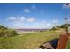 Inviting scene of the community pier, featuring a bench and a walkway amidst lush greenery with views of the blue waters beyond at 606 Indiana Ave, Crystal Beach, FL 34681