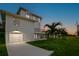 A spacious home featuring a large three-car garage, a small balcony, and verdant landscaping at 606 Indiana Ave, Crystal Beach, FL 34681