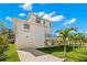 Rear exterior view of a two-story home with an attached garage and mature landscaping at 606 Indiana Ave, Crystal Beach, FL 34681