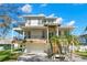 Beautiful exterior view of a modern home with a two-car garage, elevated balconies, and lush landscaping at 606 Indiana Ave, Crystal Beach, FL 34681