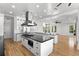 Modern open kitchen with large island, stainless steel appliances, and seamless flow to the living area at 606 Indiana Ave, Crystal Beach, FL 34681