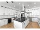 A bright kitchen with white cabinetry, stainless appliances, black countertops and hardwood floors at 606 Indiana Ave, Crystal Beach, FL 34681