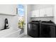 Functional laundry room with modern washer/dryer, sink, and storage cabinets at 606 Indiana Ave, Crystal Beach, FL 34681