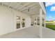 Outdoor patio with concrete floor, covered ceiling and double door entry to the house at 606 Indiana Ave, Crystal Beach, FL 34681