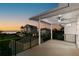 Covered patio offers stunning sunset views of the ocean, with black railings and a ceiling fan for added comfort at 606 Indiana Ave, Crystal Beach, FL 34681