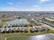 An aerial view of a neighborhood surrounding a pond with a fountain in the middle on a sunny day at 10523 Penny Gale Loop, San Antonio, FL 33576