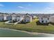 A home overlooking a pond with fenced backyards in a neighborhood is shown from an aerial view at 10523 Penny Gale Loop, San Antonio, FL 33576