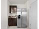 Stainless steel refrigerator and dark wood cabinets in bright kitchen space at 10523 Penny Gale Loop, San Antonio, FL 33576