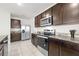 Well-equipped kitchen features stainless steel appliances and rich dark wood cabinetry at 10523 Penny Gale Loop, San Antonio, FL 33576