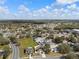 A sunny neighborhood aerial view showcasing the landscape and homes with white fences and mature trees at 4604 Hunts Ave, Plant City, FL 33566