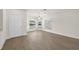 Bright living room featuring wood-look flooring, white walls, and a front door at 4604 Hunts Ave, Plant City, FL 33566