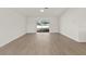 Bright living room with a wood floor and sliding glass door to the outdoor space and fenced yard at 4604 Hunts Ave, Plant City, FL 33566