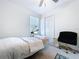 Bright bedroom with a serene spa-like setup, featuring a plush bed and a modern chair at 6744 Back Forty Loop, Zephyrhills, FL 33541