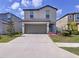Two-story home showcases neutral gray exterior, well-manicured lawn, and a welcoming front entrance with ample parking at 6744 Back Forty Loop, Zephyrhills, FL 33541