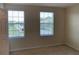 Cozy bedroom with two windows providing plenty of natural light and neutral colored walls at 7037 Towering Spruce Dr, Riverview, FL 33578