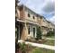 Modern townhome exterior with neutral tones, blue door and well-maintained landscaping at 7037 Towering Spruce Dr, Riverview, FL 33578