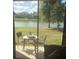 View from the patio with a table and chairs, perfect for enjoying the serene water view at 7037 Towering Spruce Dr, Riverview, FL 33578