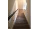 Carpeted staircase leading to the second floor with wood railing at 7037 Towering Spruce Dr, Riverview, FL 33578