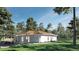 Outdoor patio area perfect for entertaining with lush green lawn and mature trees at 15945 Viscount Cir, Port Charlotte, FL 33981