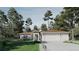 Beautiful one-story home with a three-car garage, lush landscaping, and towering trees in a serene setting at 15945 Viscount Cir, Port Charlotte, FL 33981